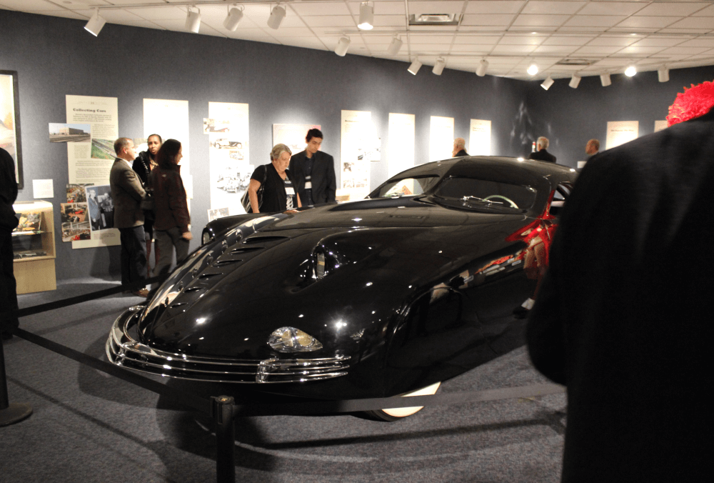 photo of people looking at a car